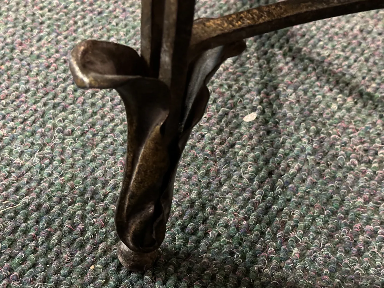 détail de la base d'une ancienne console décorative, fond textile