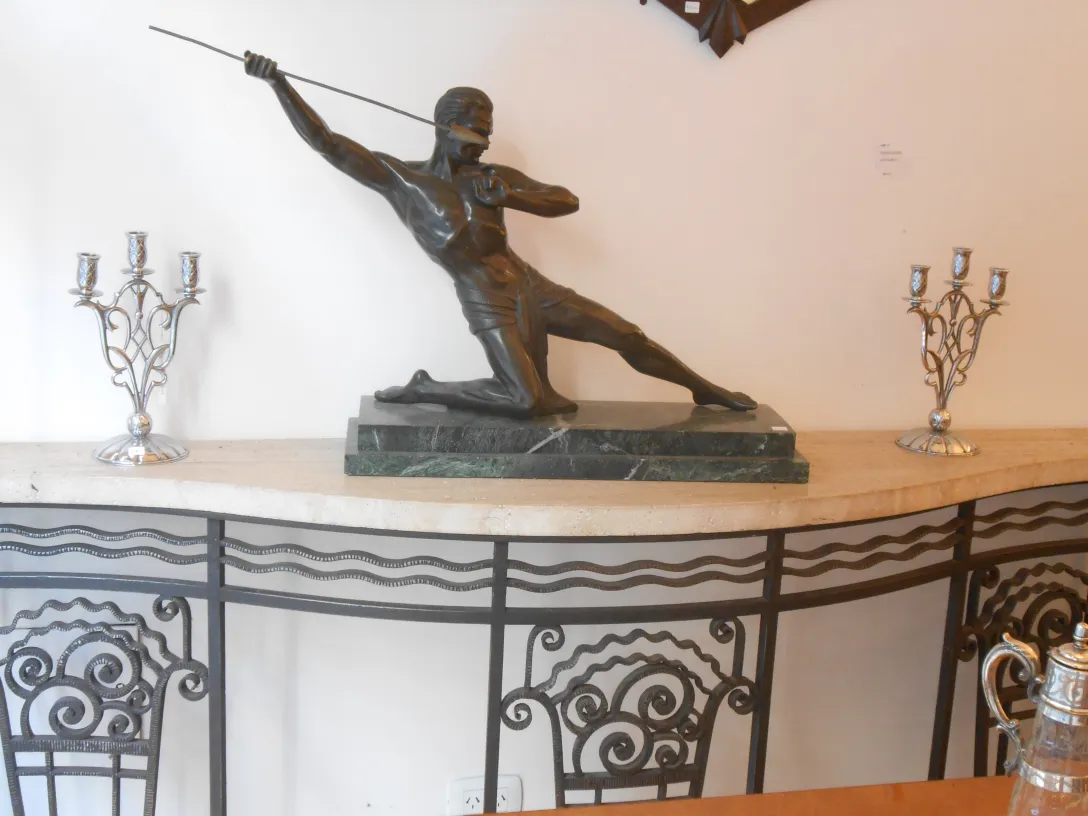 consola antigua con figura decorativa central y candelabros