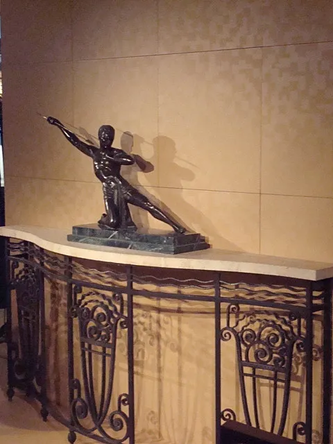 consola antigua con escultura elegante encima, decoración