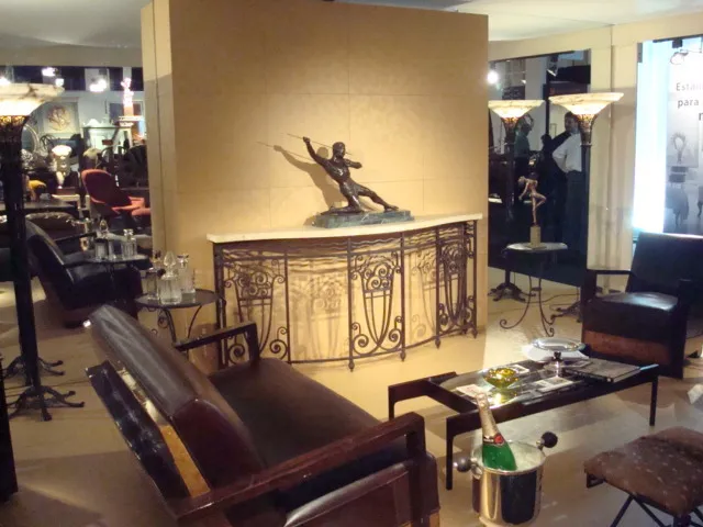 Consola antiga com figura decorativa, ambiente elegante.