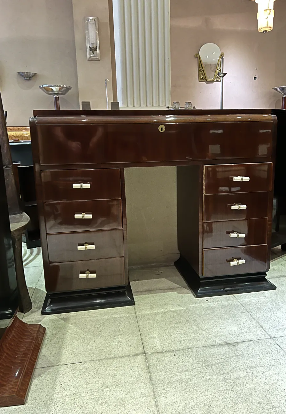 Consola antigua con varios cajones y dosificadores, en un ambiente decorativo.