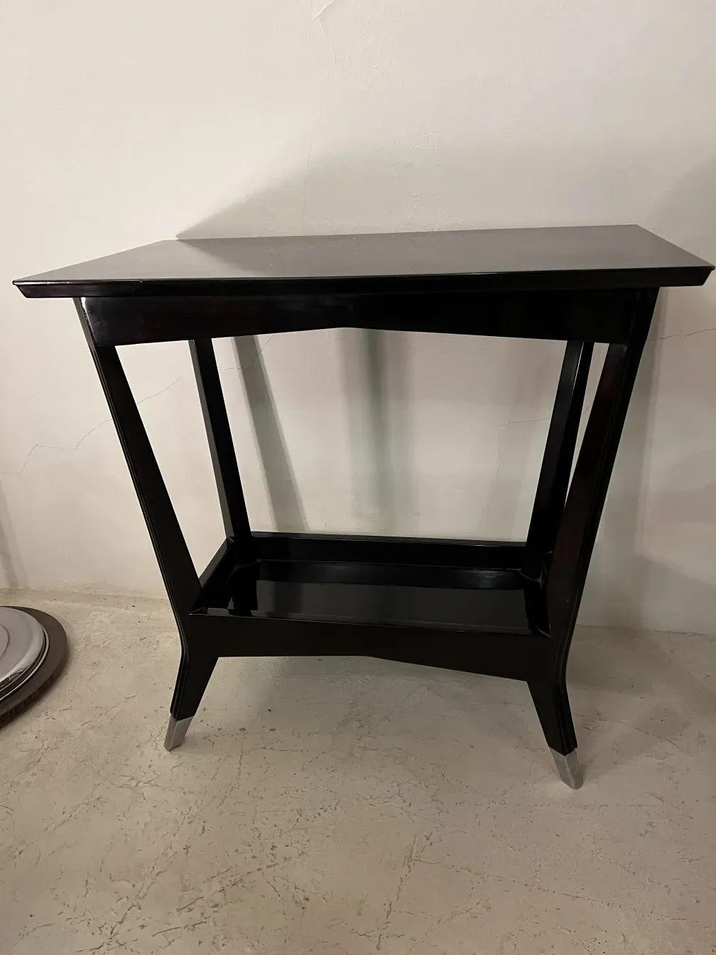 antigua consola decorativa de forma elegante y estilizada, con un fondo neutro