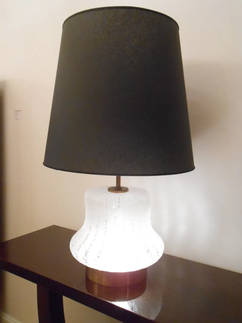 Antica console con luce e paralume nero.