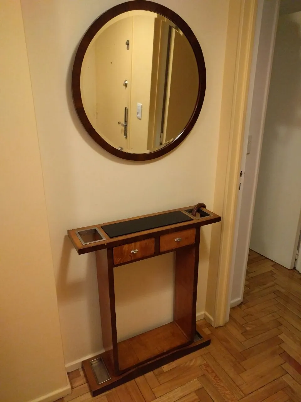 antique entry console with round mirror on the wall