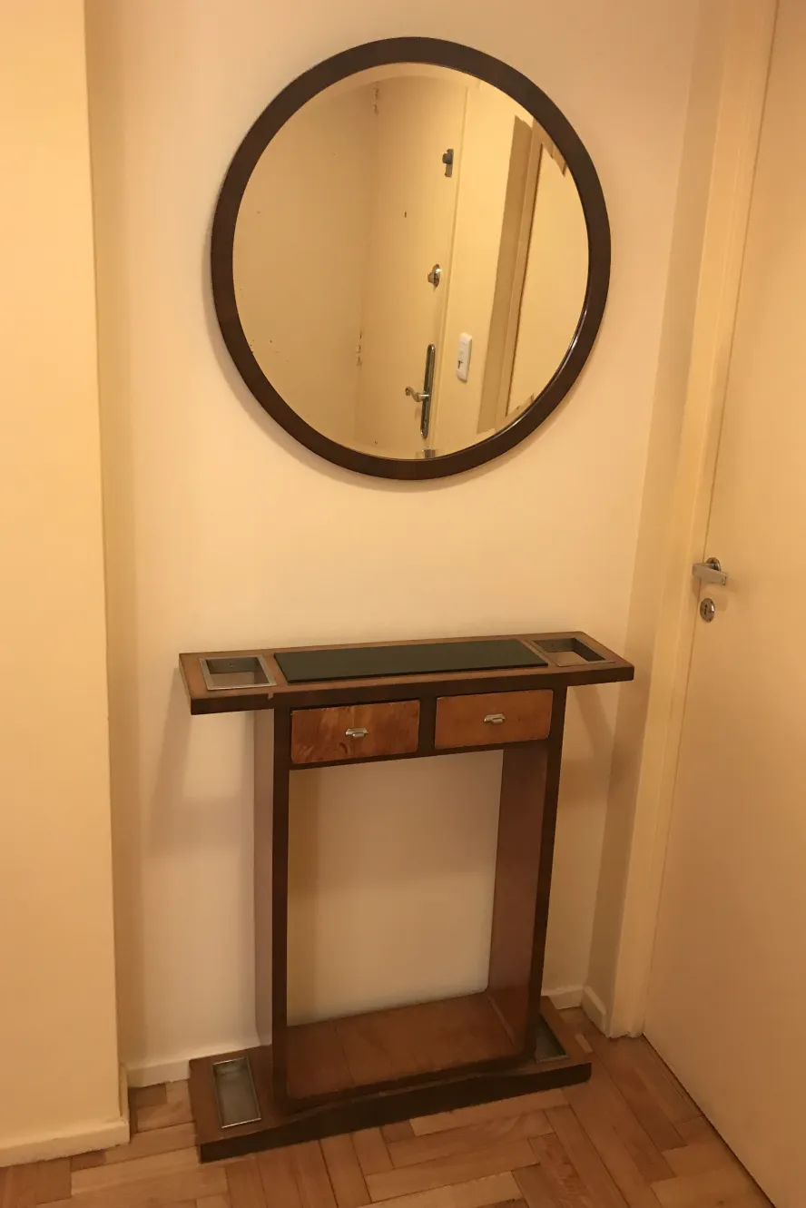 antique console in the hall with a round mirror