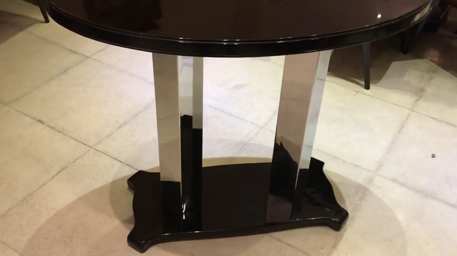 antique round console with black and chrome base, elegant design