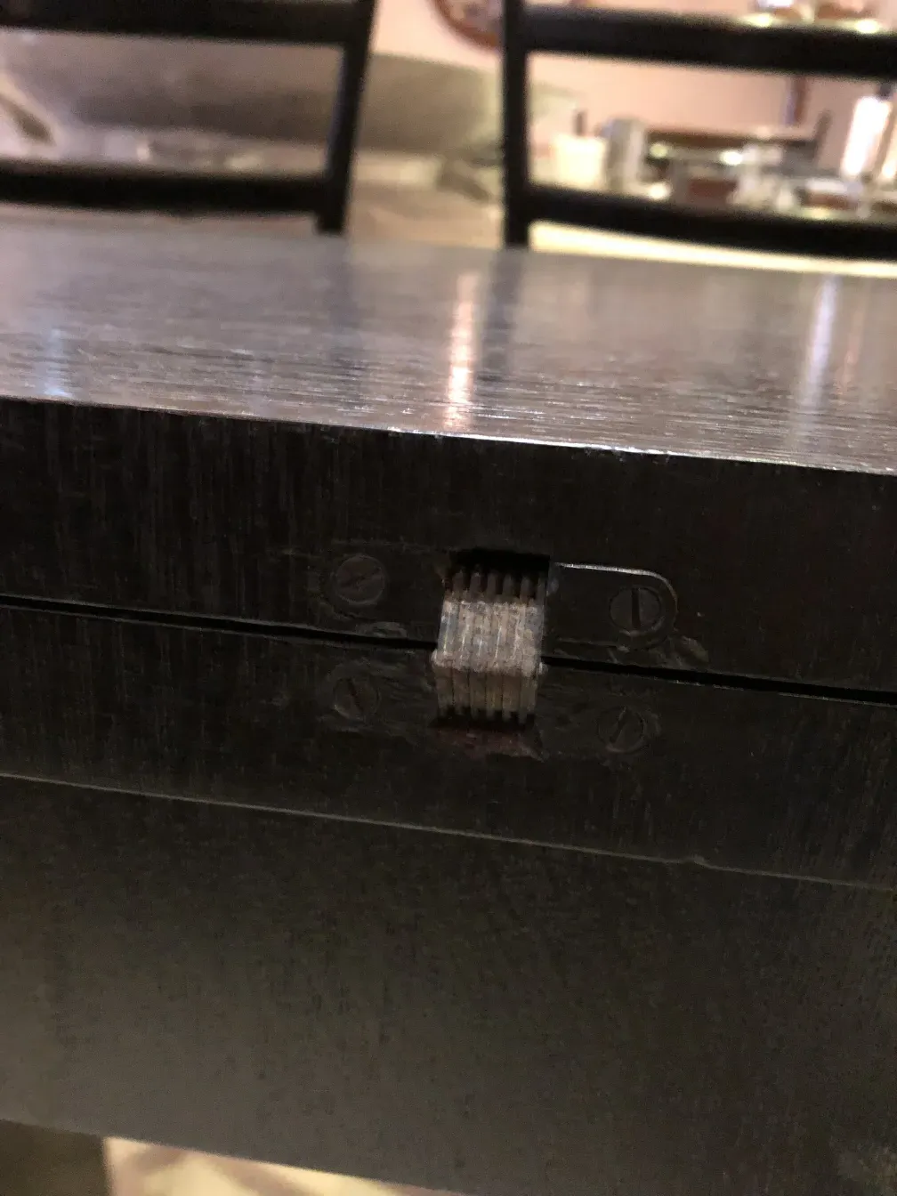 detail of an antique storage consol with hinge, neutral setting