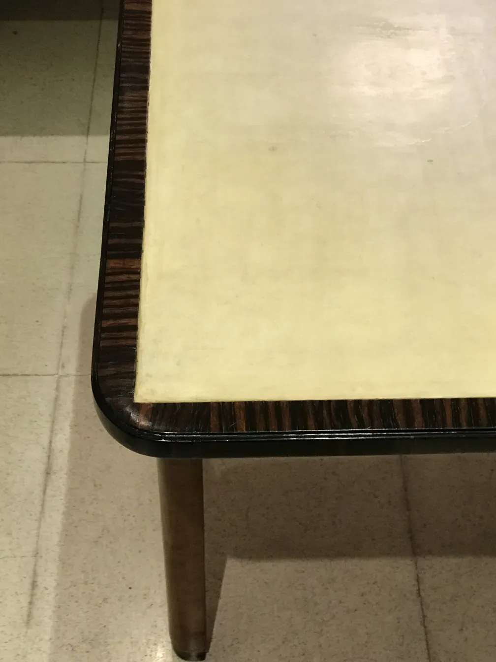 Antiga consola com topo branco e borda preta em um ambiente simples.