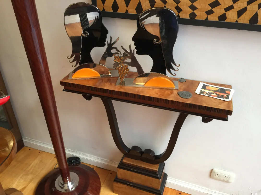 Antiga consolo decorativa com silhuetas de rostos