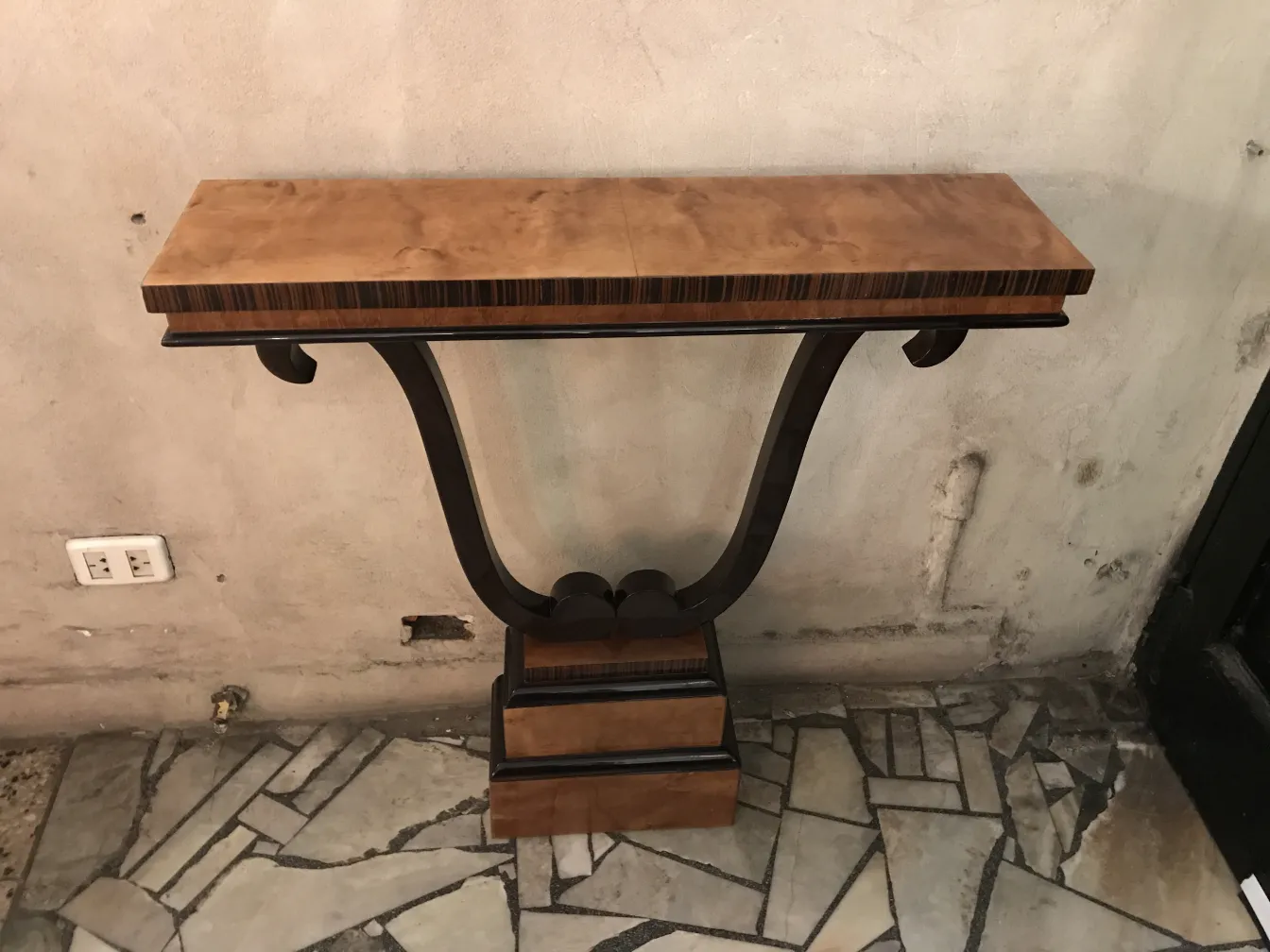 Consola antiga com design elegante, fundo neutro.