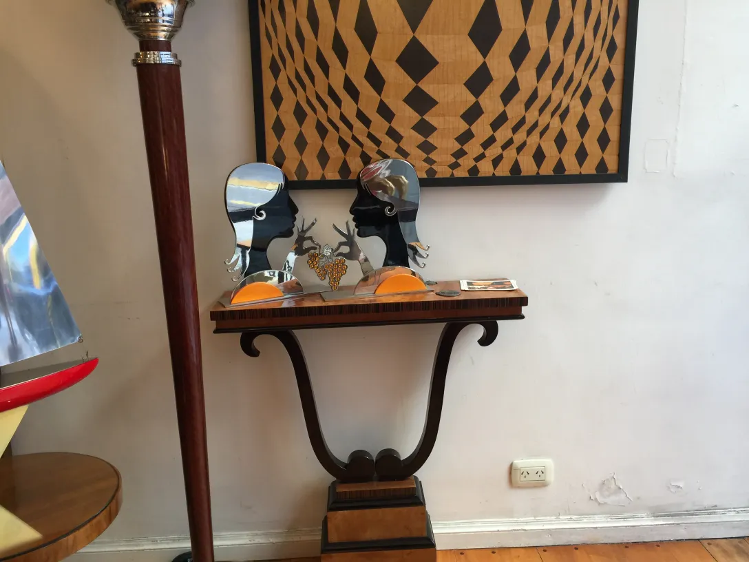 Antigua consola decorativa con esculturas y objetos en la mesa