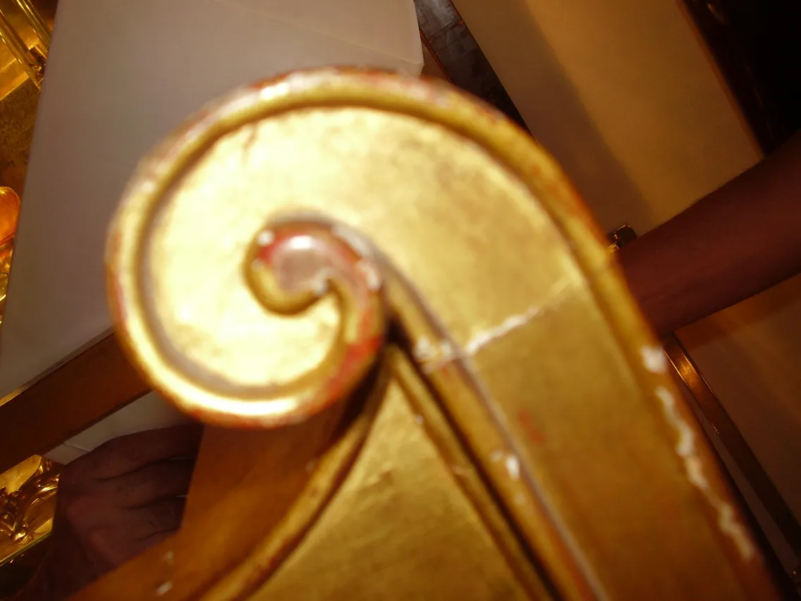 Detalles dorados de una consola antigua con un diseño decorativo.