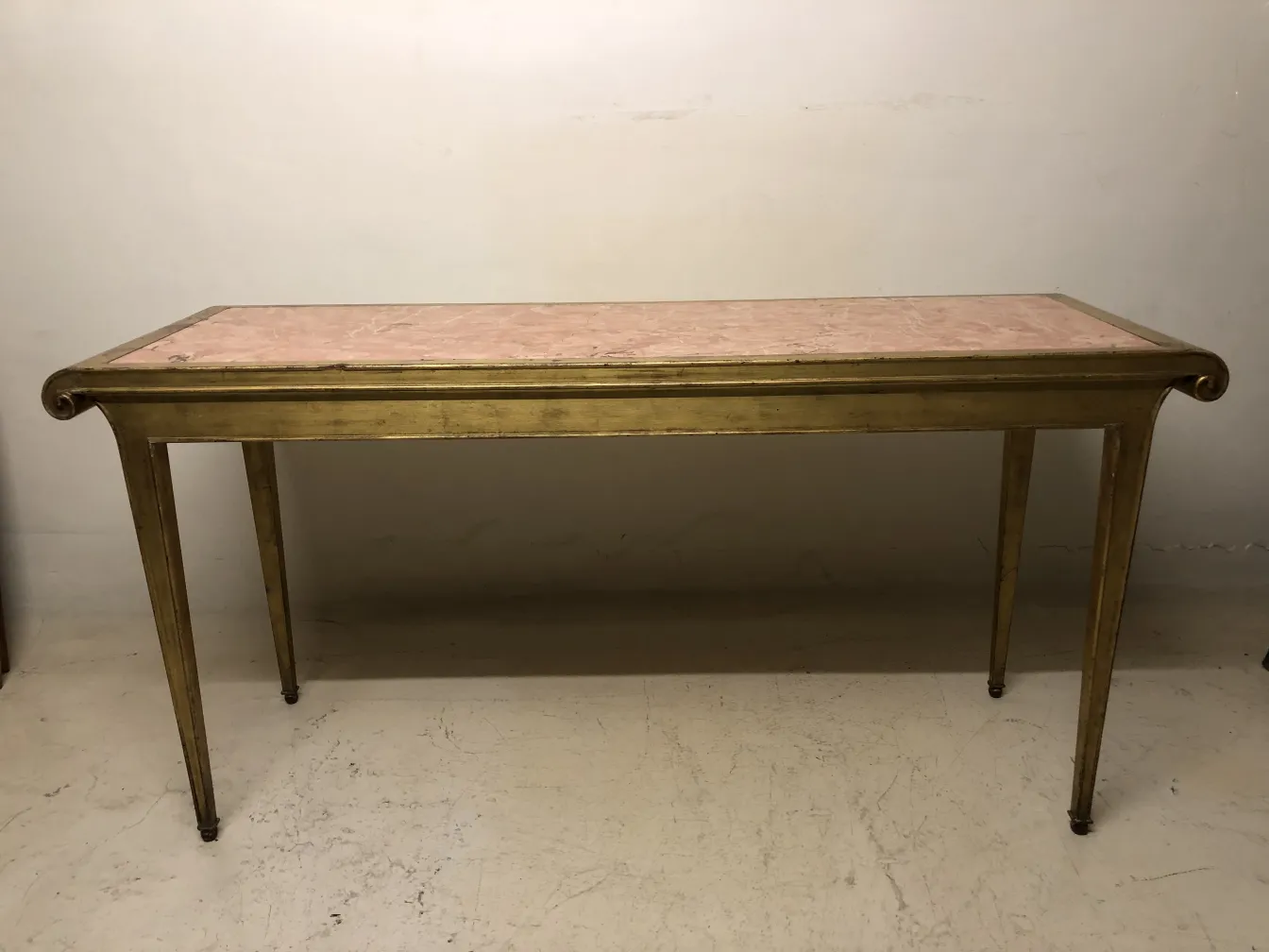 antique decorative console with elegant legs and pink surface