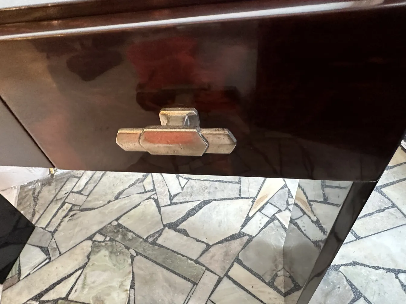 Close-up of two elegant antique consoles with a stone floor background