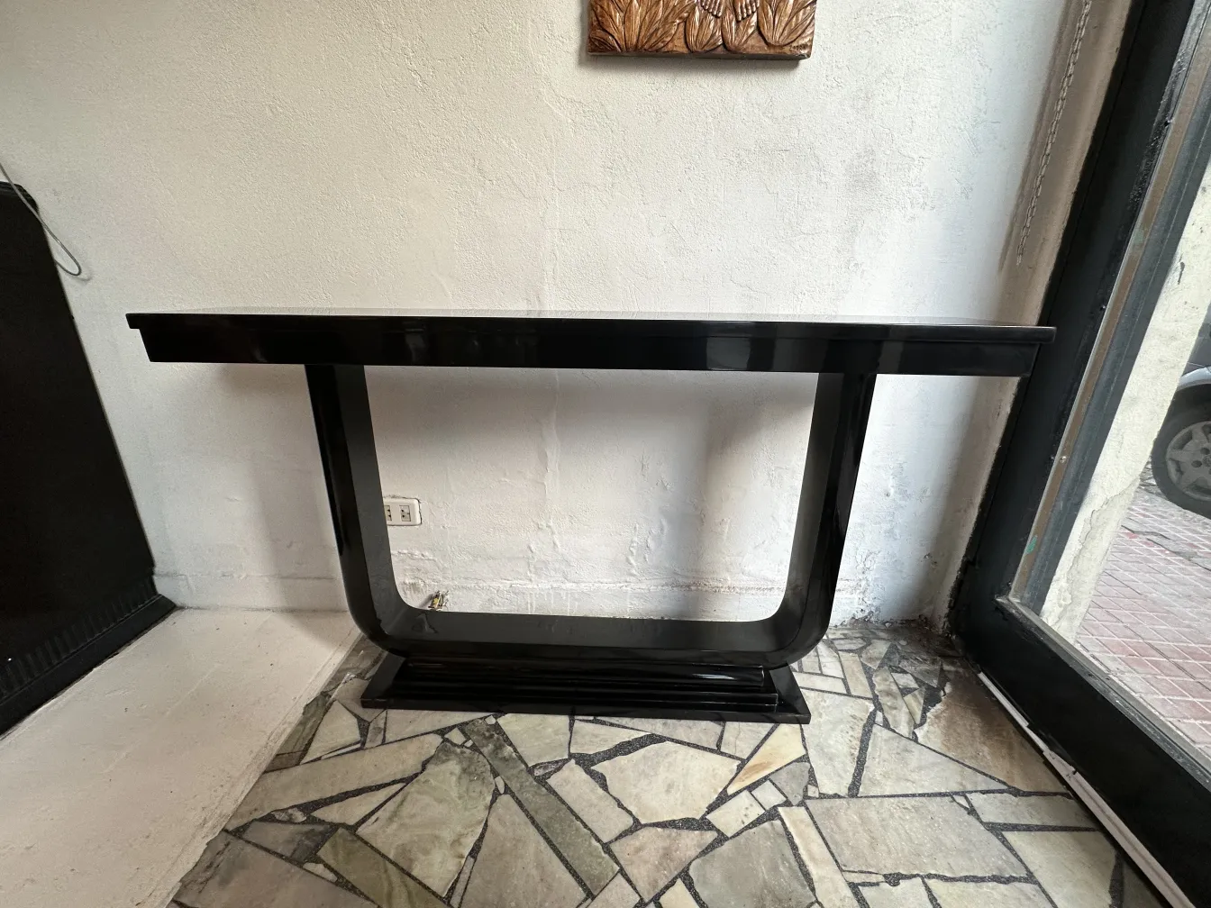 Two elegant antique consoles in a cozy setting, white wall and decorative floor.