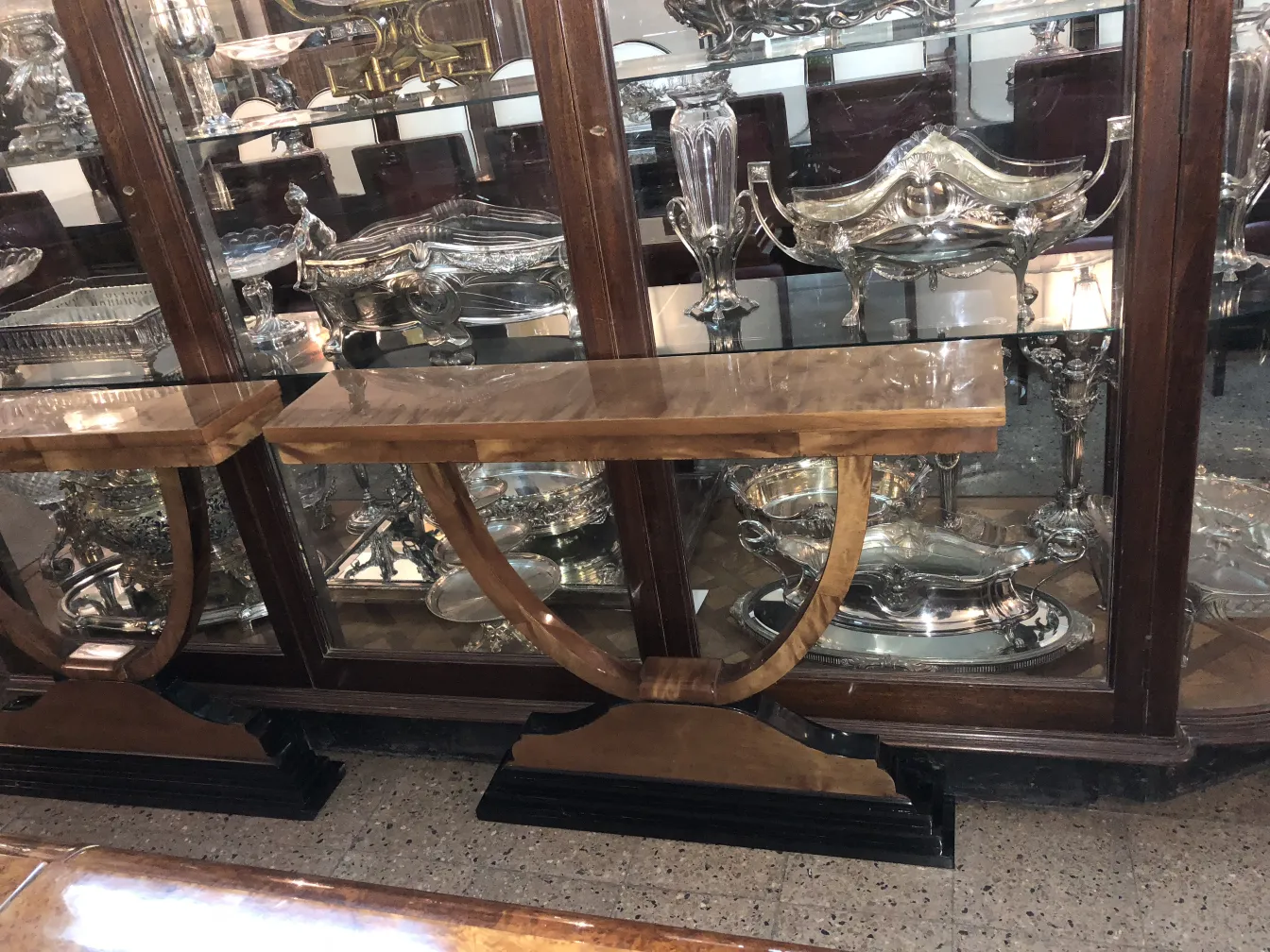 Dos consolas antiguas con diseño elegante, en un ambiente clásico.