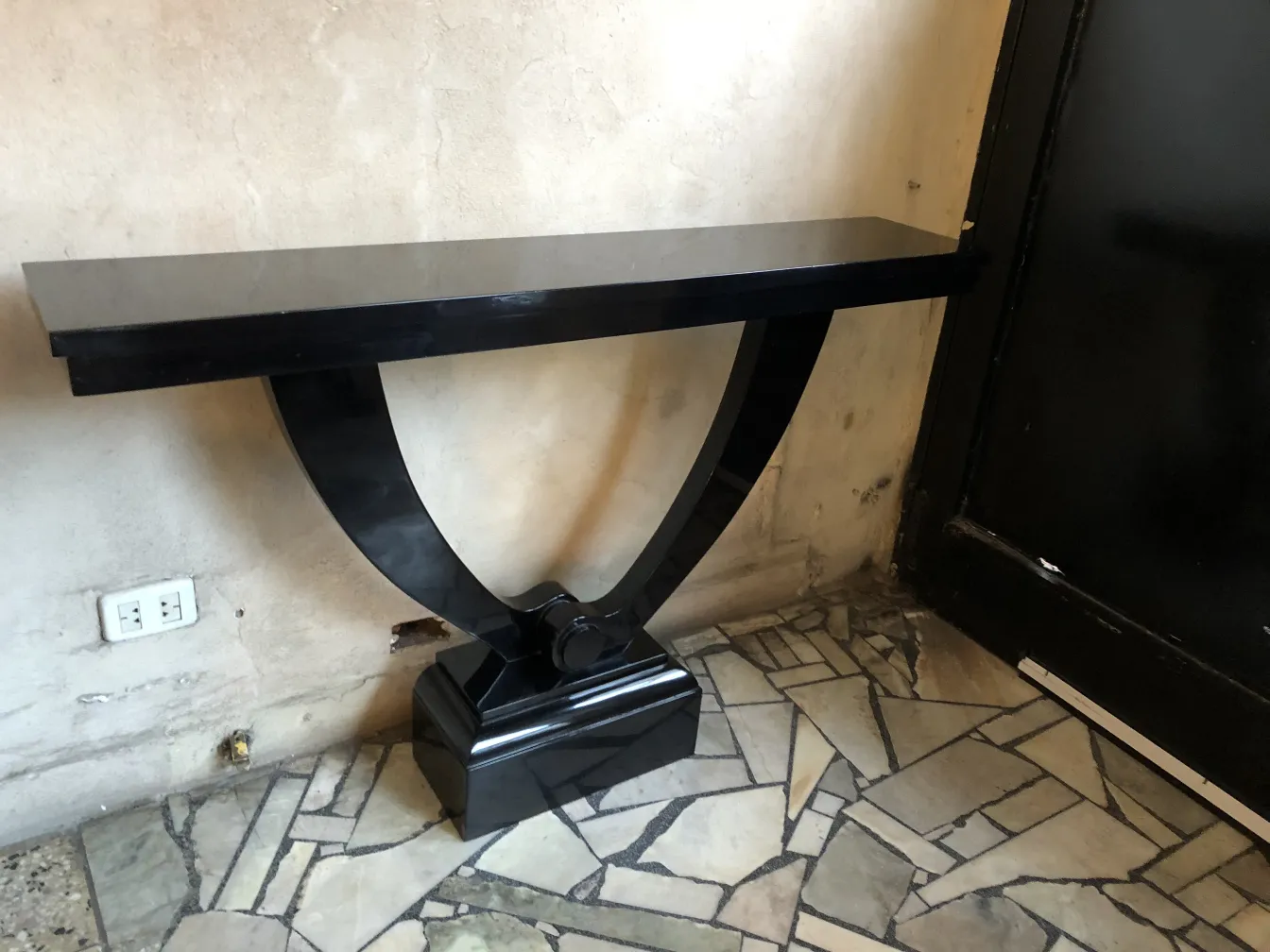 two stylish antique consoles against the wall