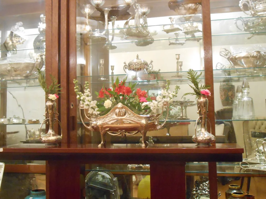 Tre consolle antiche con fiori decorativi e vasi