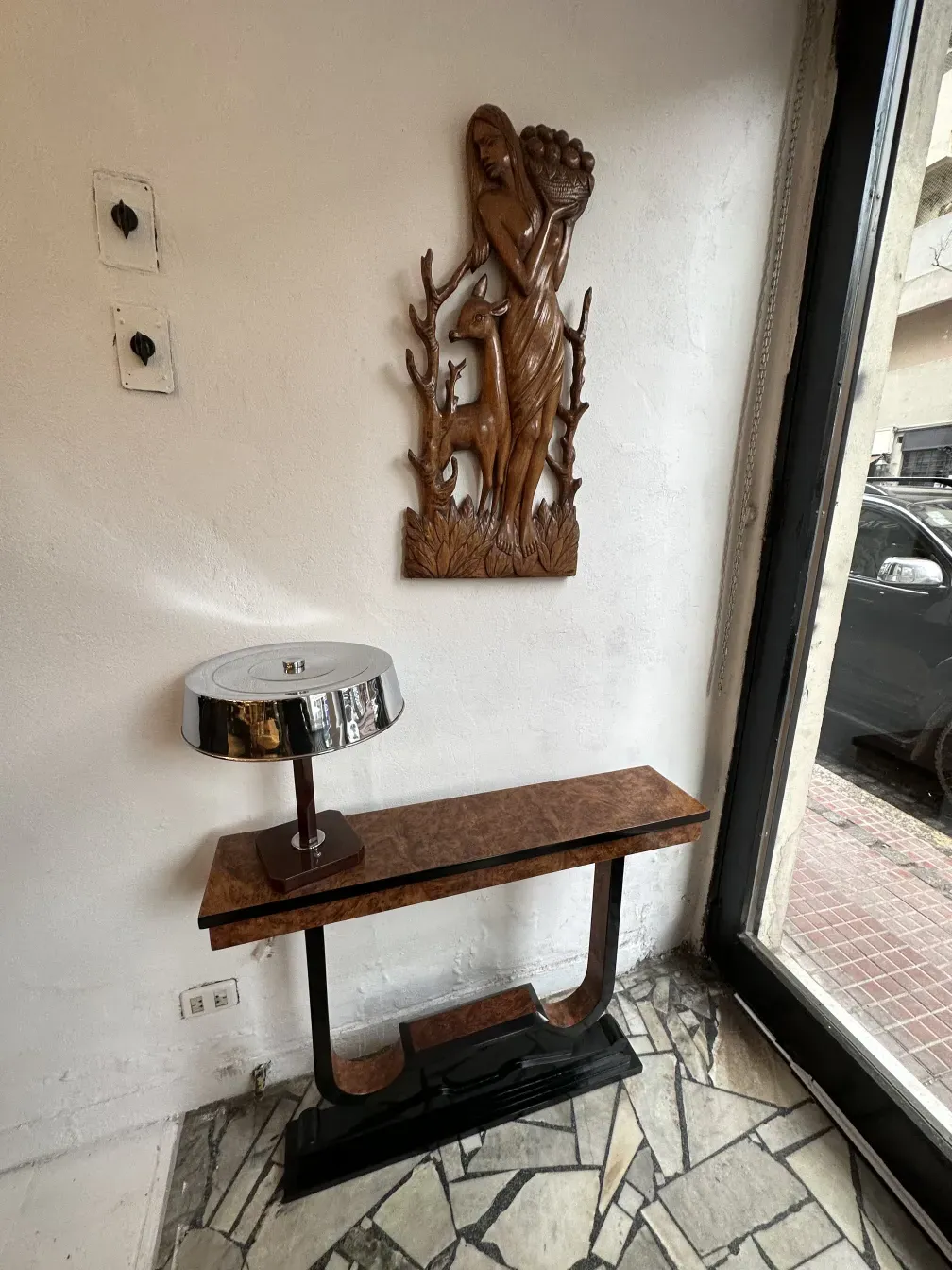 흰색 벽에 있는 고풍스러운 장식용 콘솔 테이블 세 개, 장식용 부조 옆에.