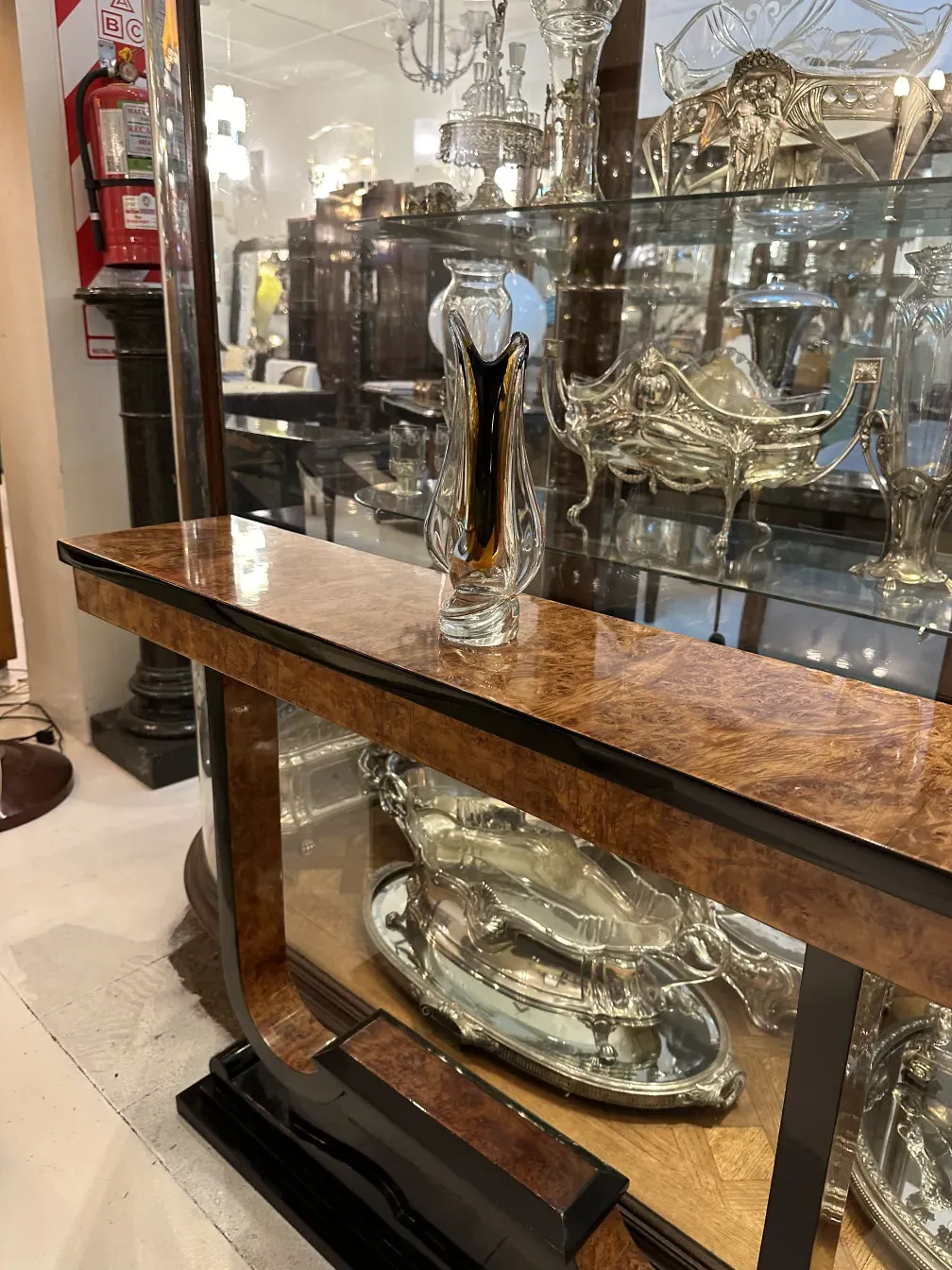 Tres consolas antiguas sobre una mesa con detalles decorativos