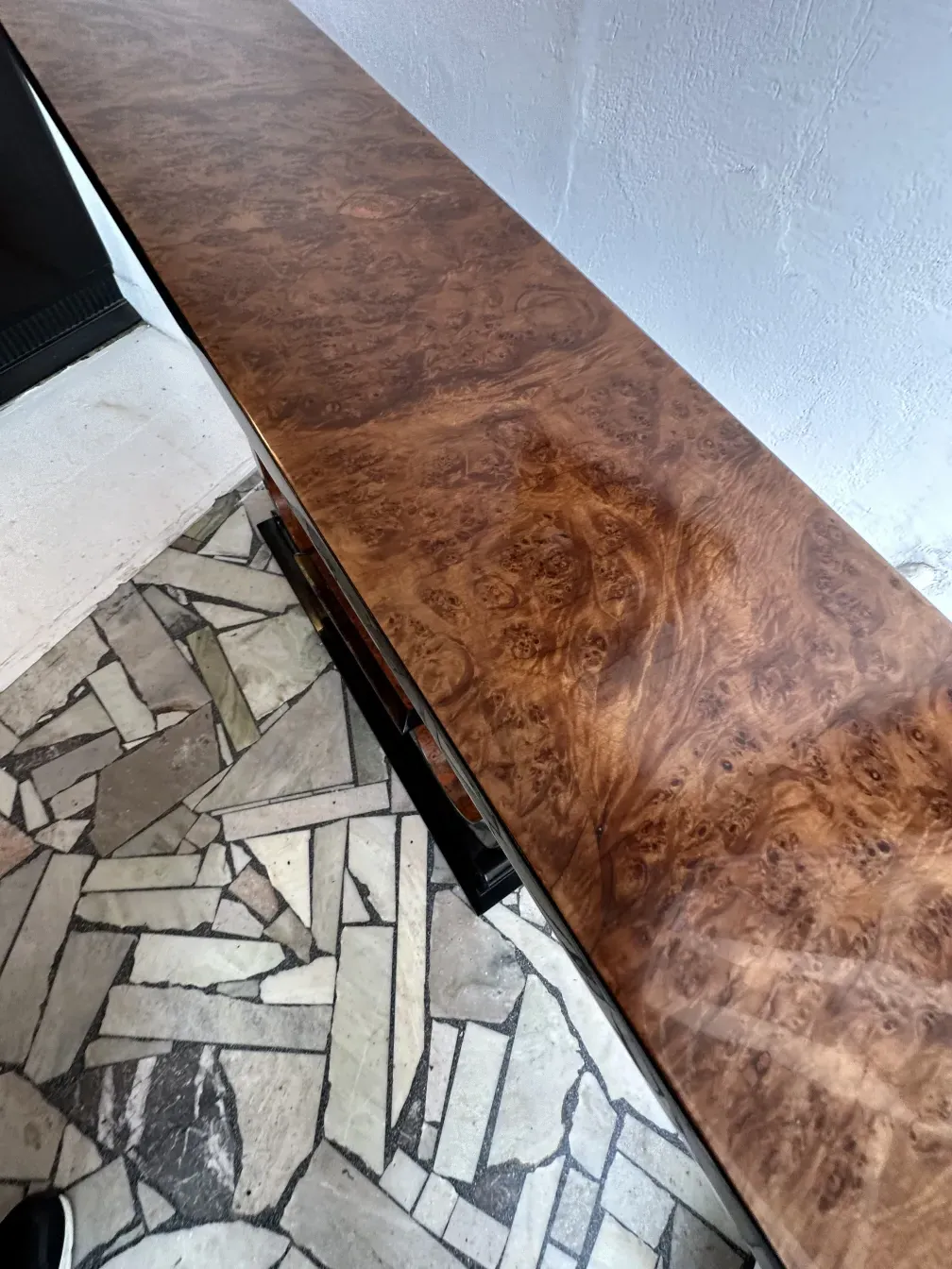 Vista superior de tres consolas antiguas con diseño elegante sobre un fondo de piedra