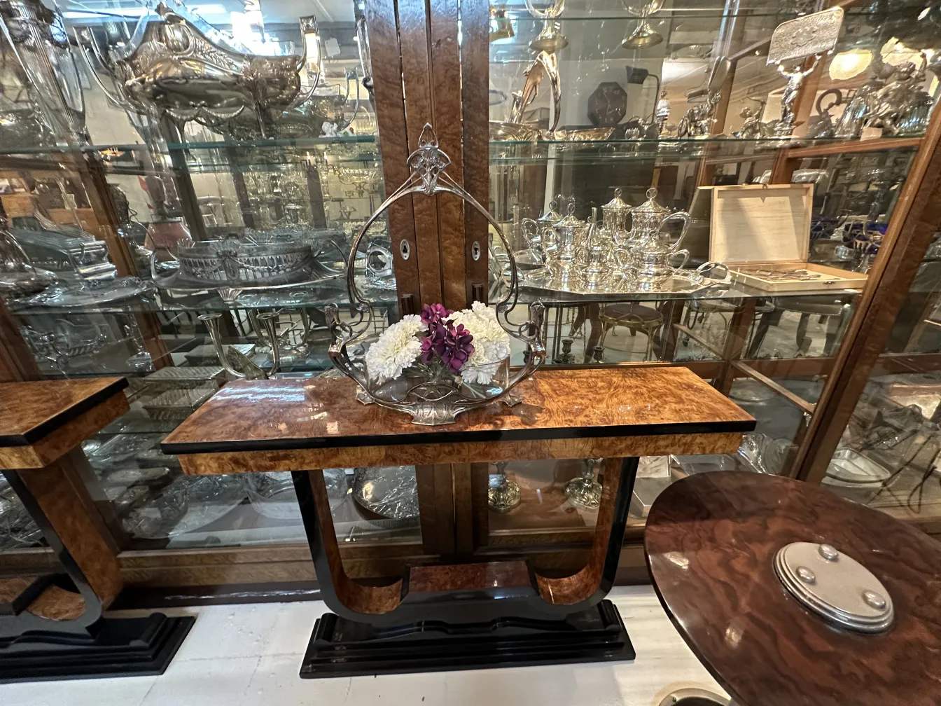 Three antique consoles with decorative flowers on top.