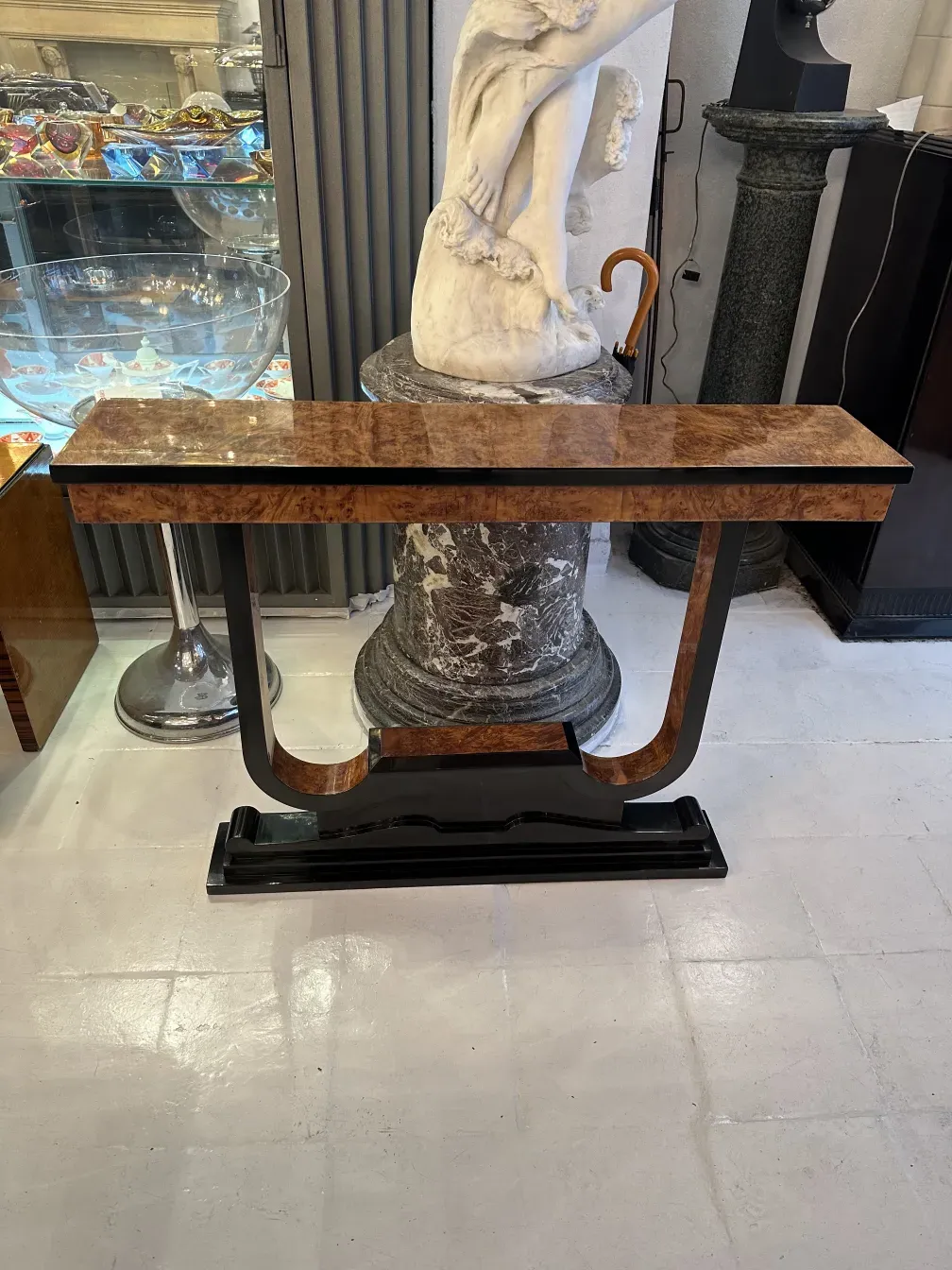 Drei antike Konsolentische in einem klassischen Ambiente mit einer Statue und beleuchtetem Hintergrund