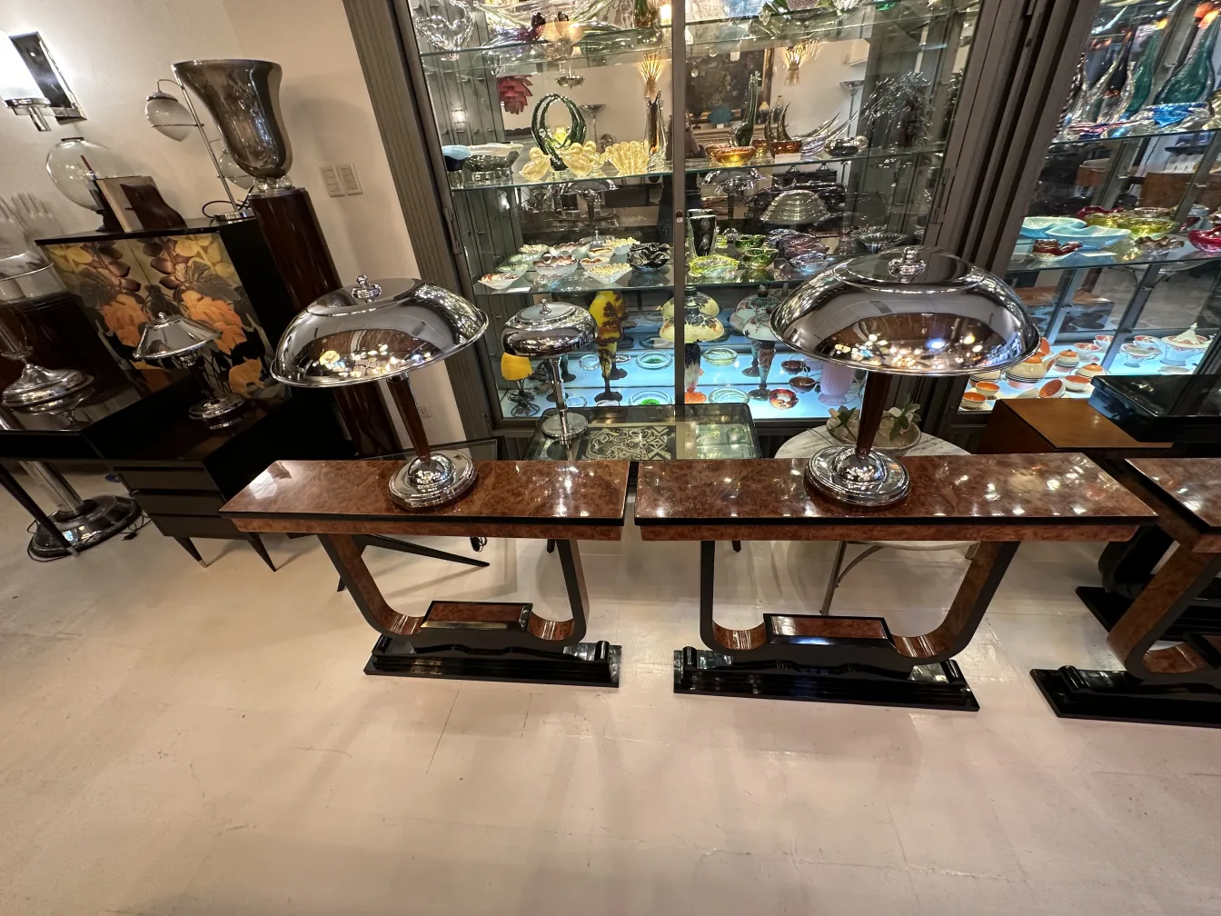 Trois dresuars antiques dans un cadre élégant, avec des lampes brillantes.