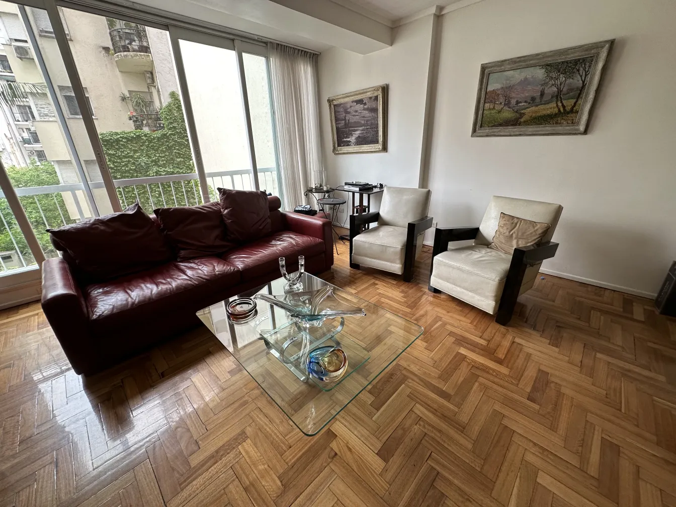 Candelabre ancien dans un cadre contemporain avec des chaises claires.