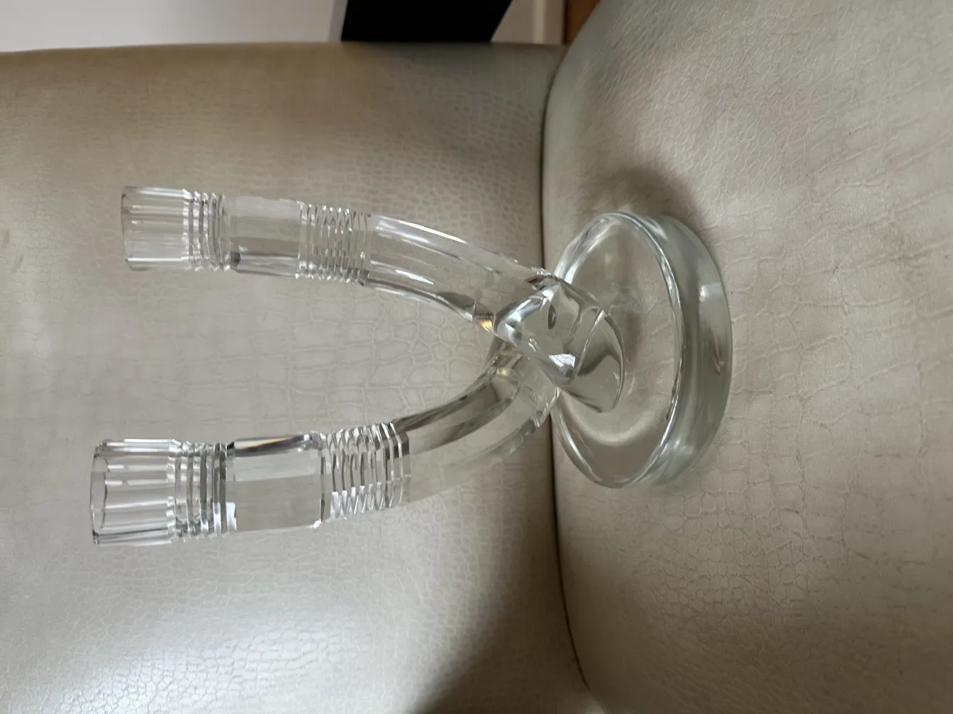 Antiker transparenter Kandelaber auf einer weichen Oberfläche, elegant im Design.