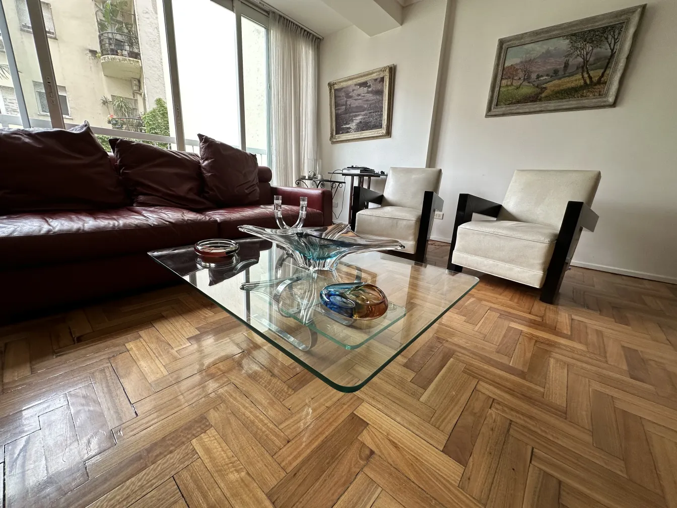 Antiker Kandelaber in einem modernen Wohnzimmer mit Stühlen.