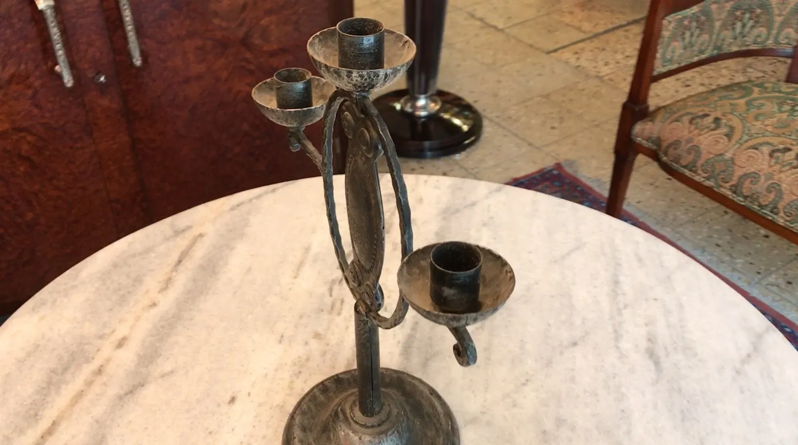 Candelabro antigo em uma mesa de mármore com base redonda