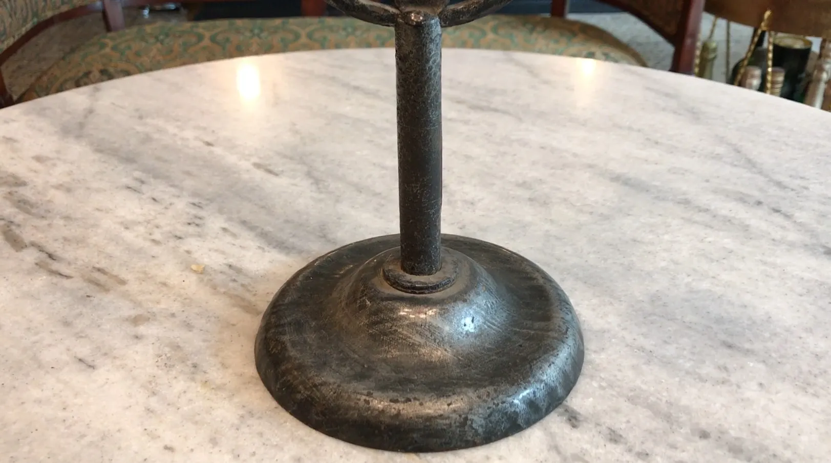 antique candelabra with round base on marble table surface