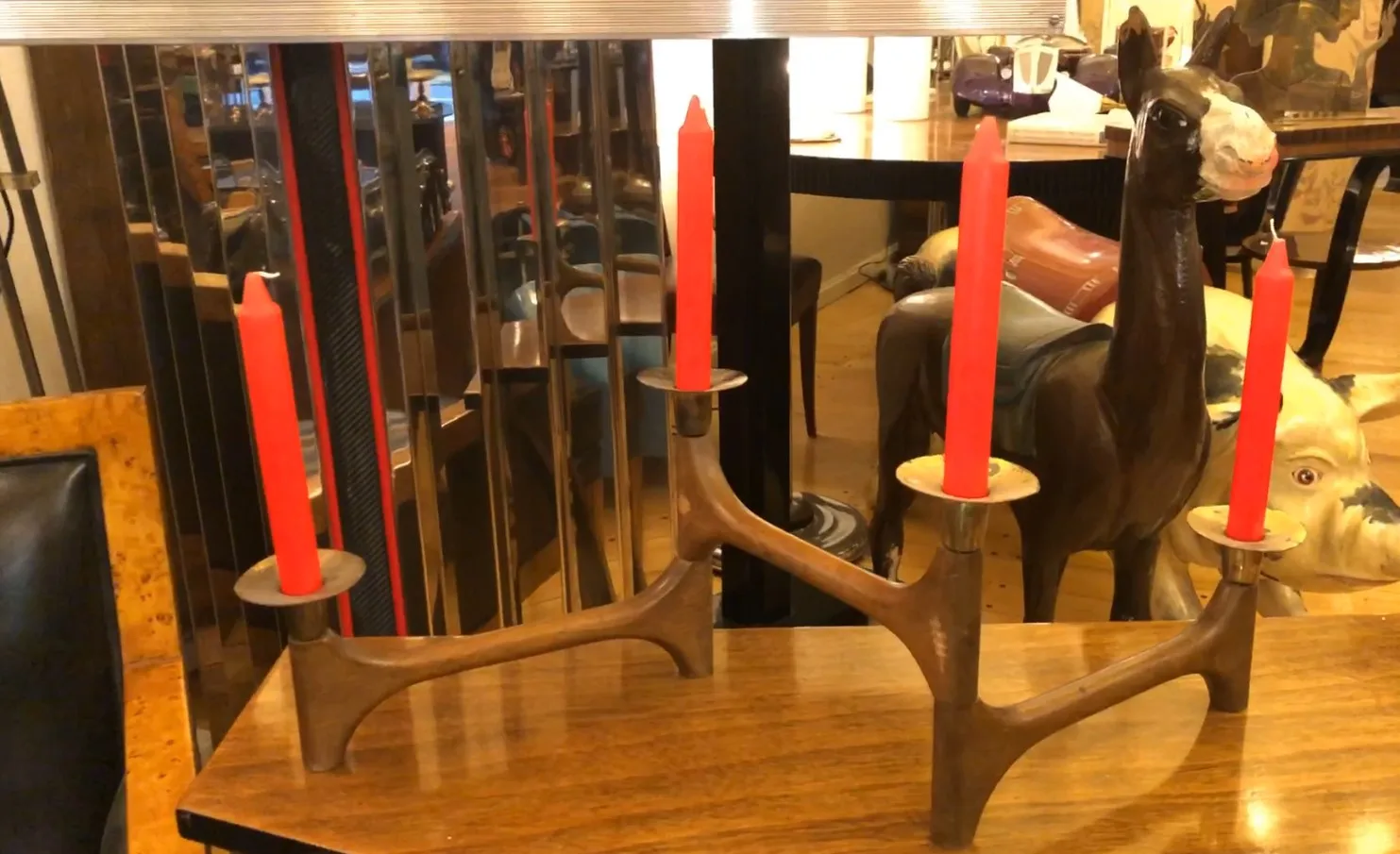 Candelabro antiguo de tres brazos con velas rojas en un ambiente elegante