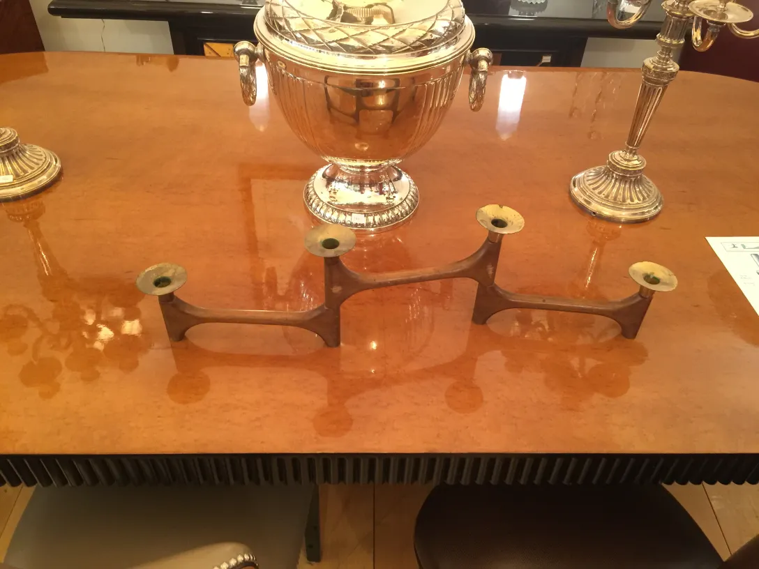 三臂古老烛台在桌子上，旁边有蜡烛