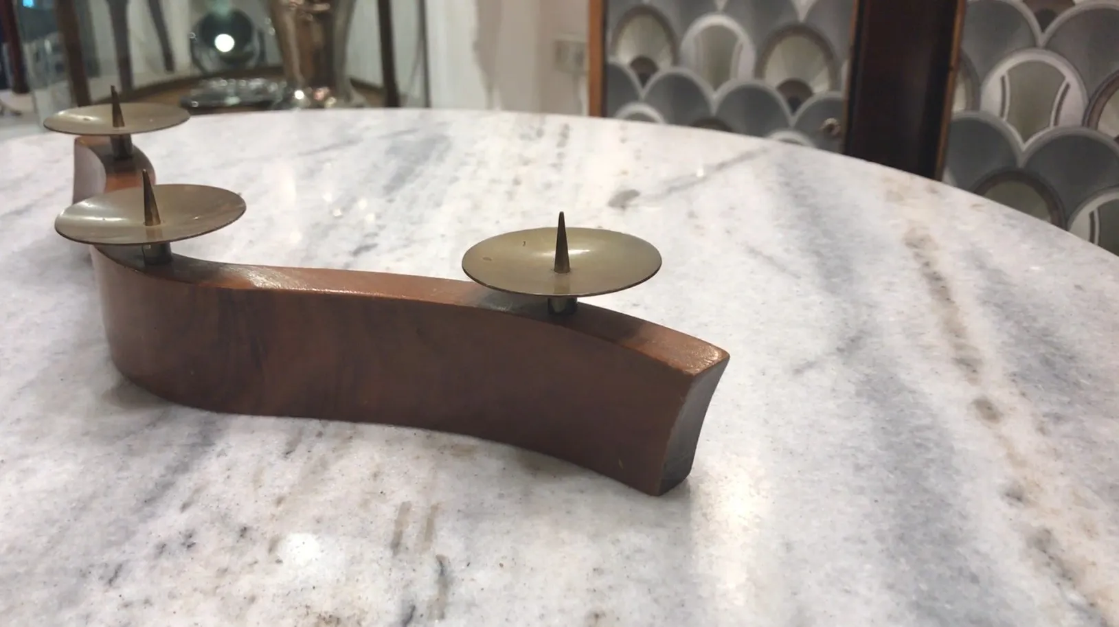 Candelabre ancien décoratif sur une table en marbre dans une ambiance élégante.