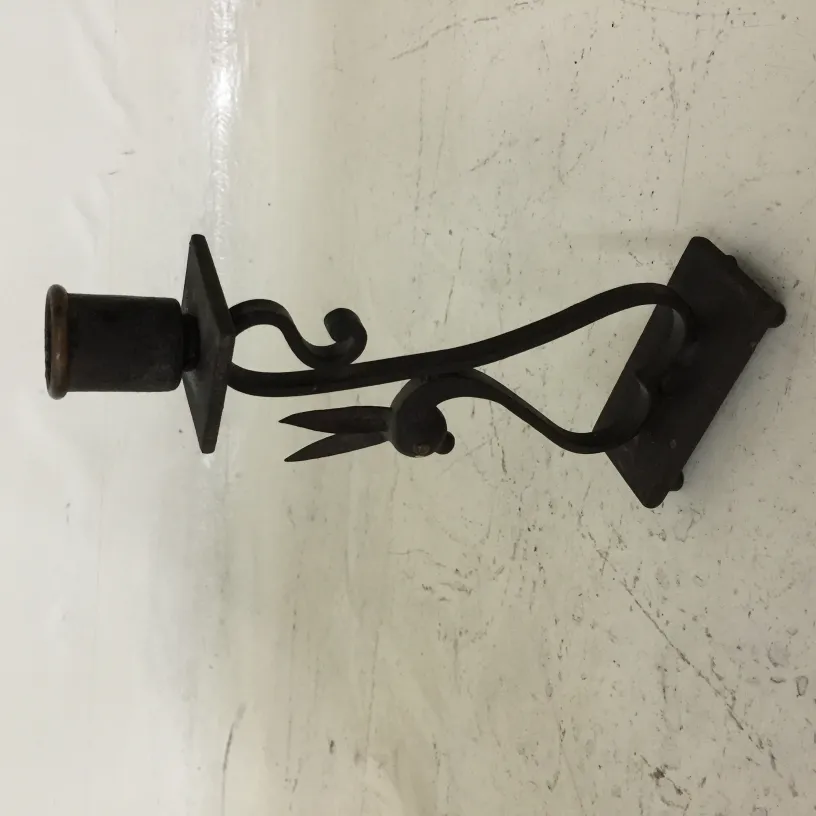 Candelabro antico con forma elegante e dettagli decorativi su sfondo chiaro.