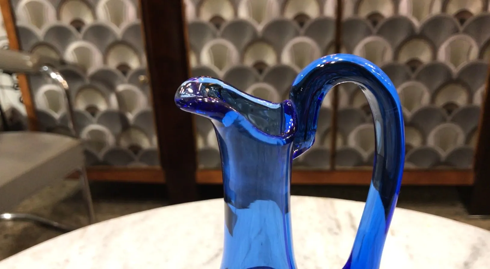 jarra antigua de cristal azul en una superficie clara