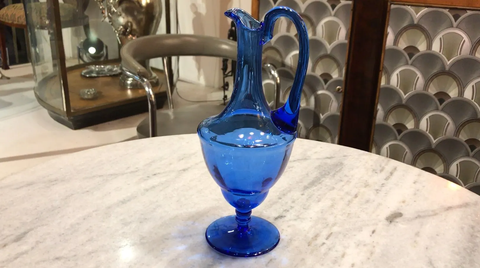 Antigua jarra azul decorativa en mesa con fondo