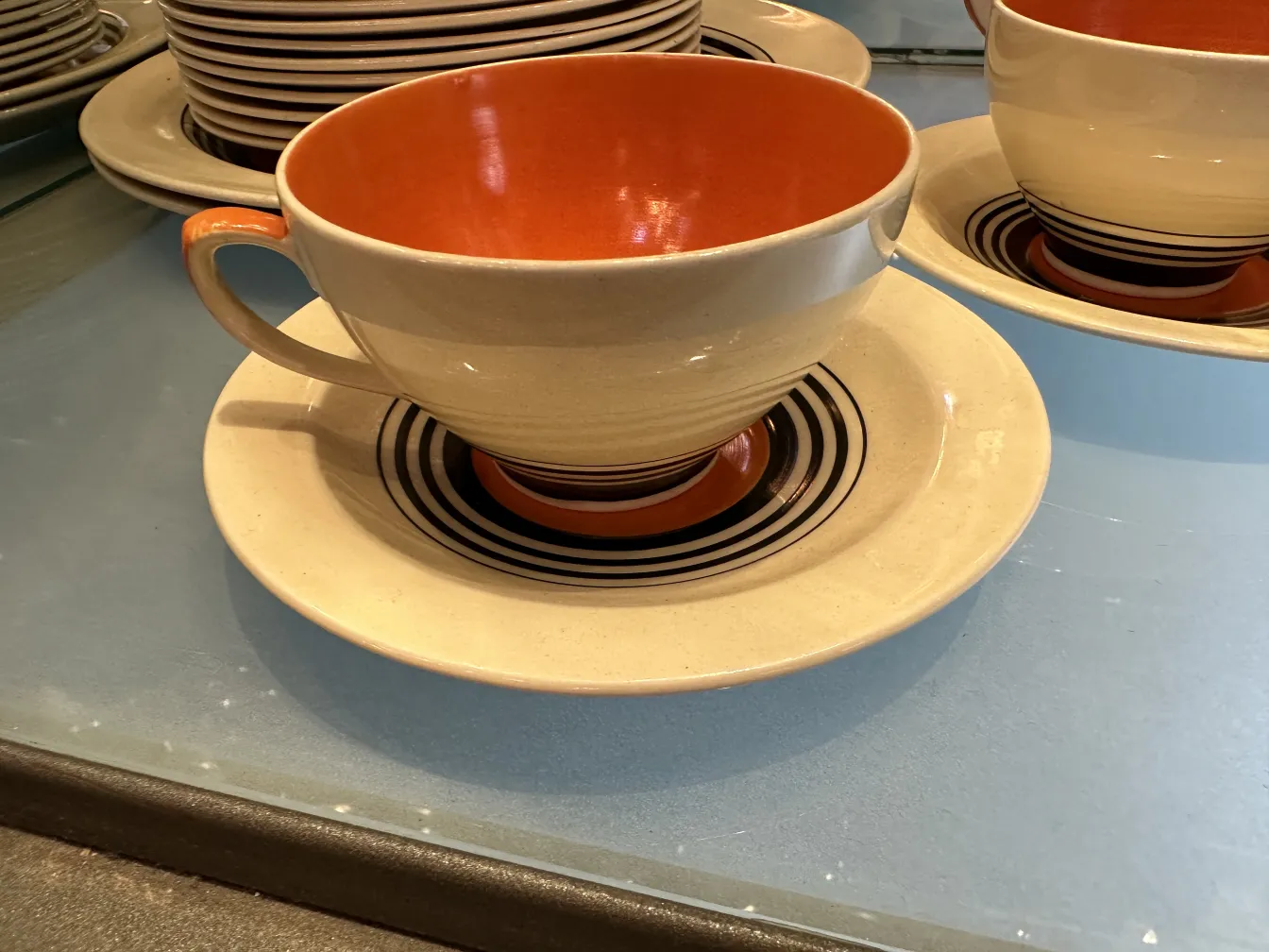 juego de té antiguo con colores cálidos y líneas elegantes en taza y plato