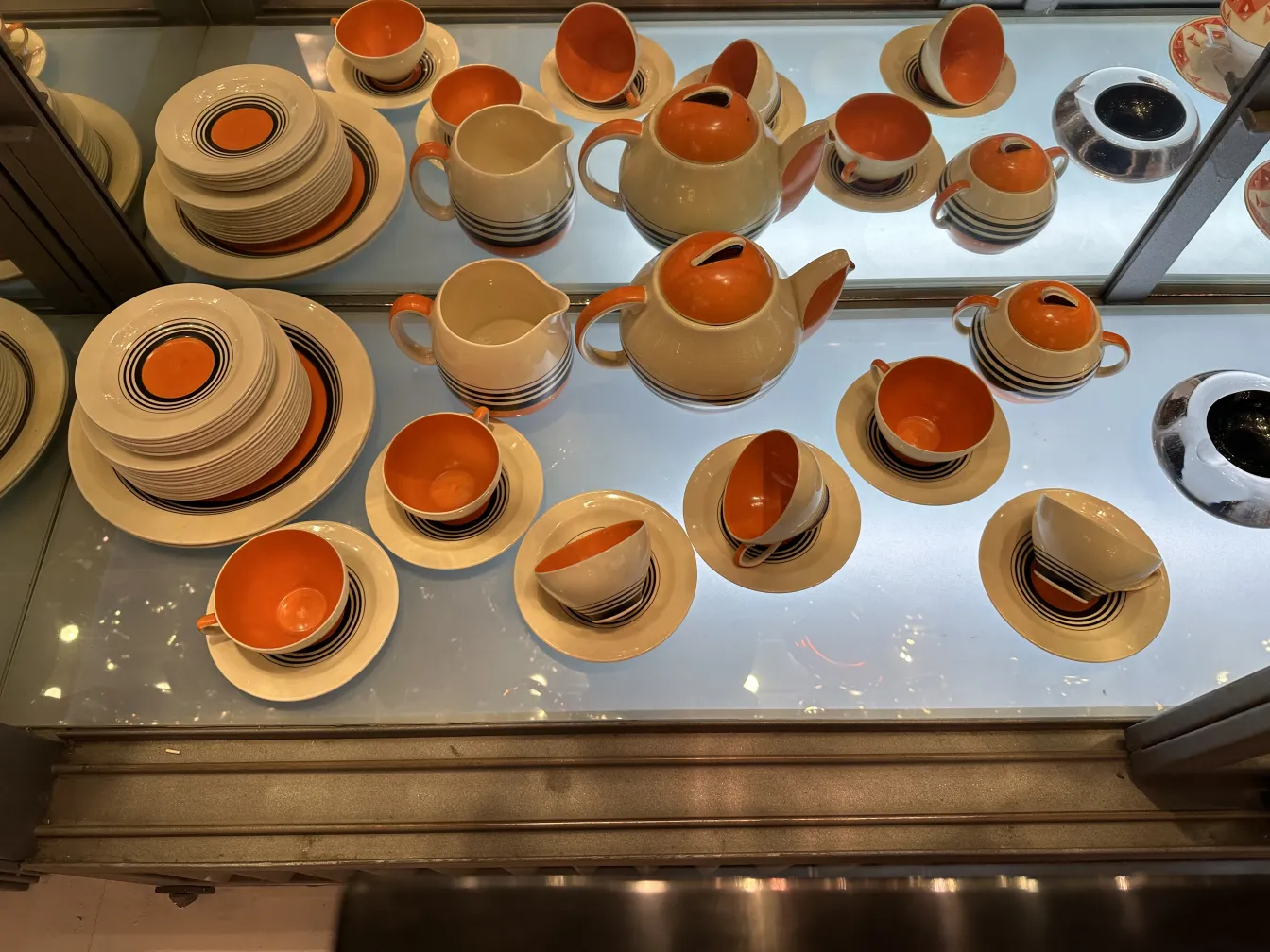 antikes Teeset mit cremefarbenen und orangen Tassen und Tellern, gestreifte Details