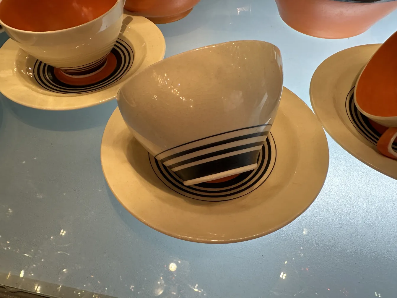 juego de té antiguo con tazas y platos en tonos claros y oscuros