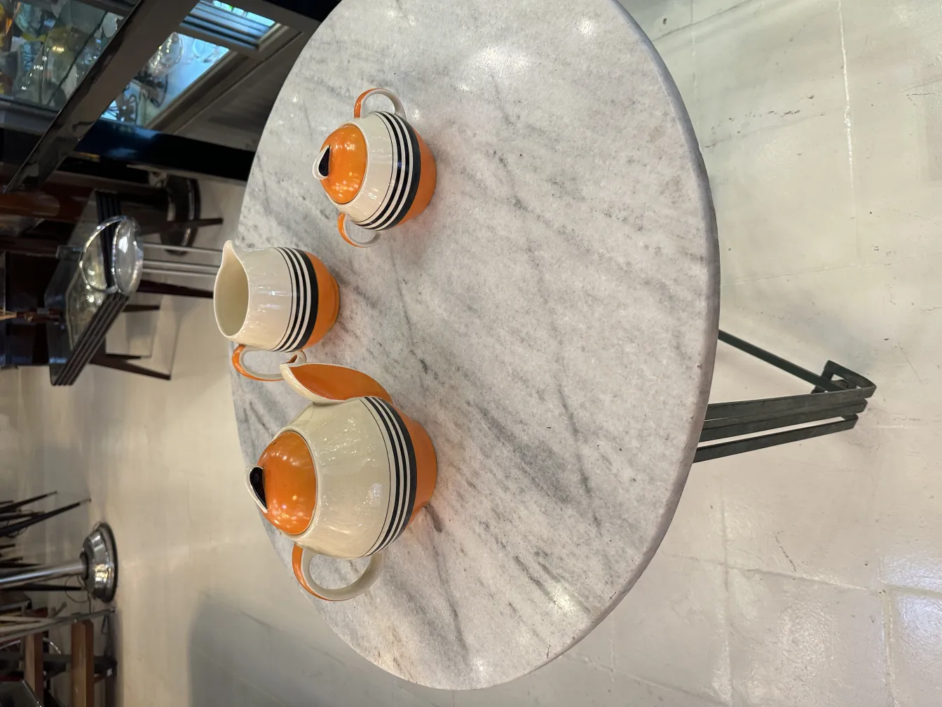 대리석 테이블 위에 있는 고대 티 세트, 컵과 주전자 포함, 매력적인 디자인과 생생한 색상