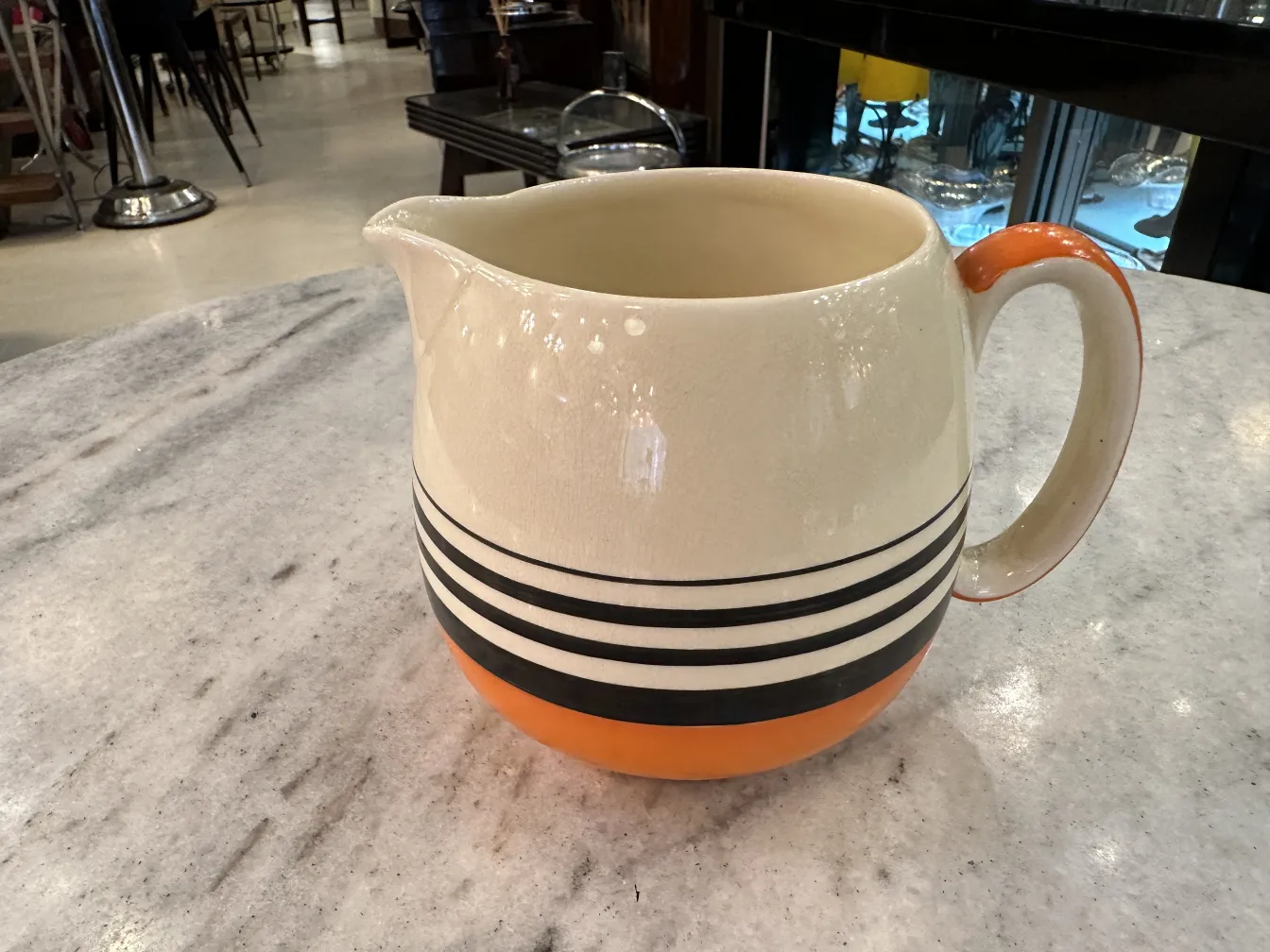 decorated antique pitcher with stripes, marble background