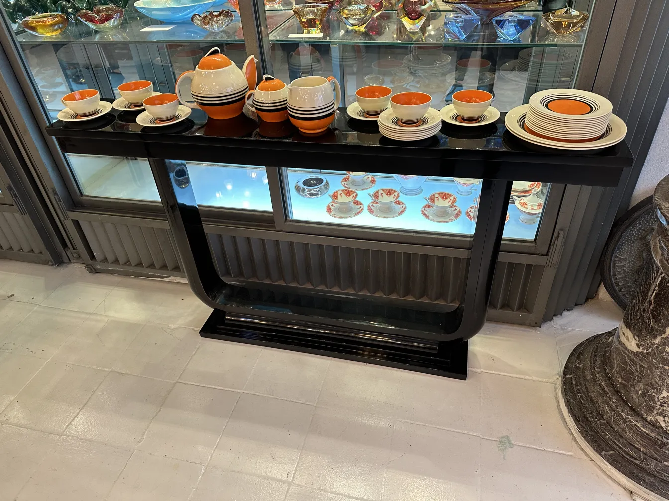 juego de té antiguo sobre mesa negra, decorado con platos coloridos