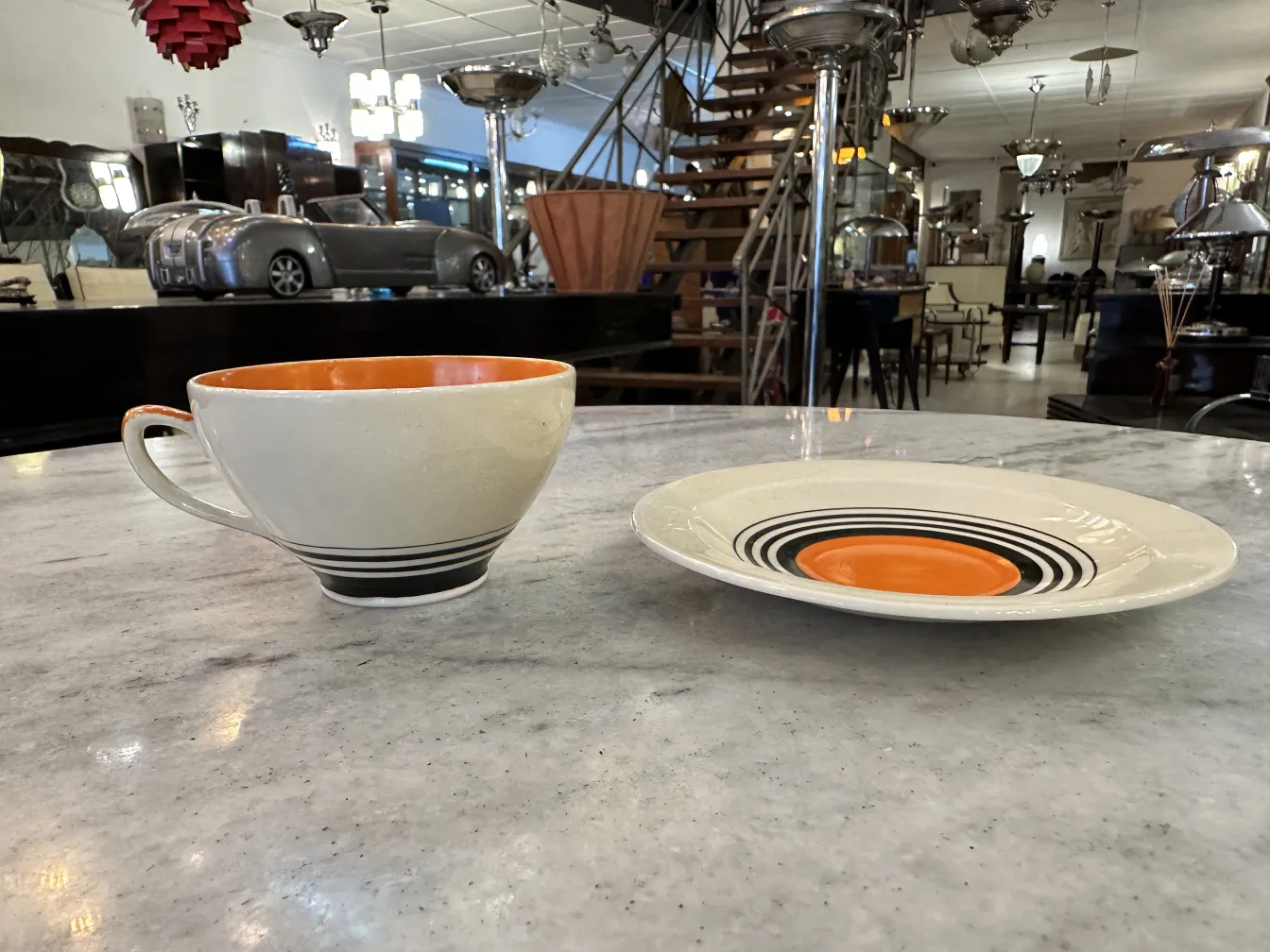 Juego de té antiguo con tazas y platos decorativos en naranja y blanco