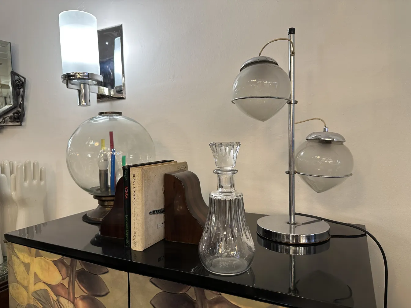 bottiglia antica su tavolo con lampade e libri