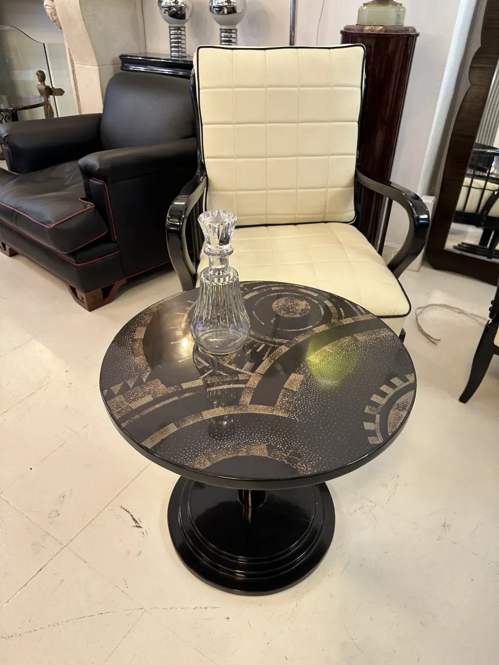 botellón antiguo cristal decorado en mesa redonda negra