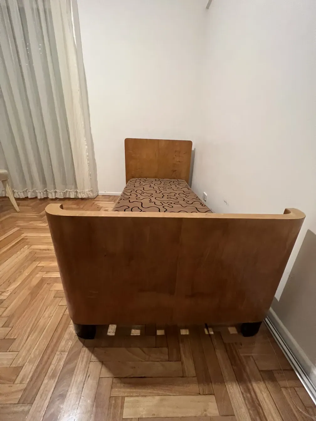 Antique bed with unique design in a neutral setting.