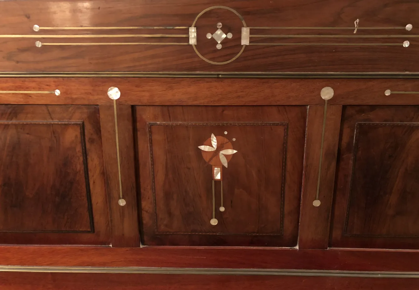 Cama antiga de madeira com detalhes decorativos no cabeçote.